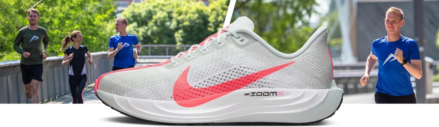 Nike Pegasus Plus running shoe in white and coral with ZoomX midsole, shown alongside runners on an outdoor bridge path.