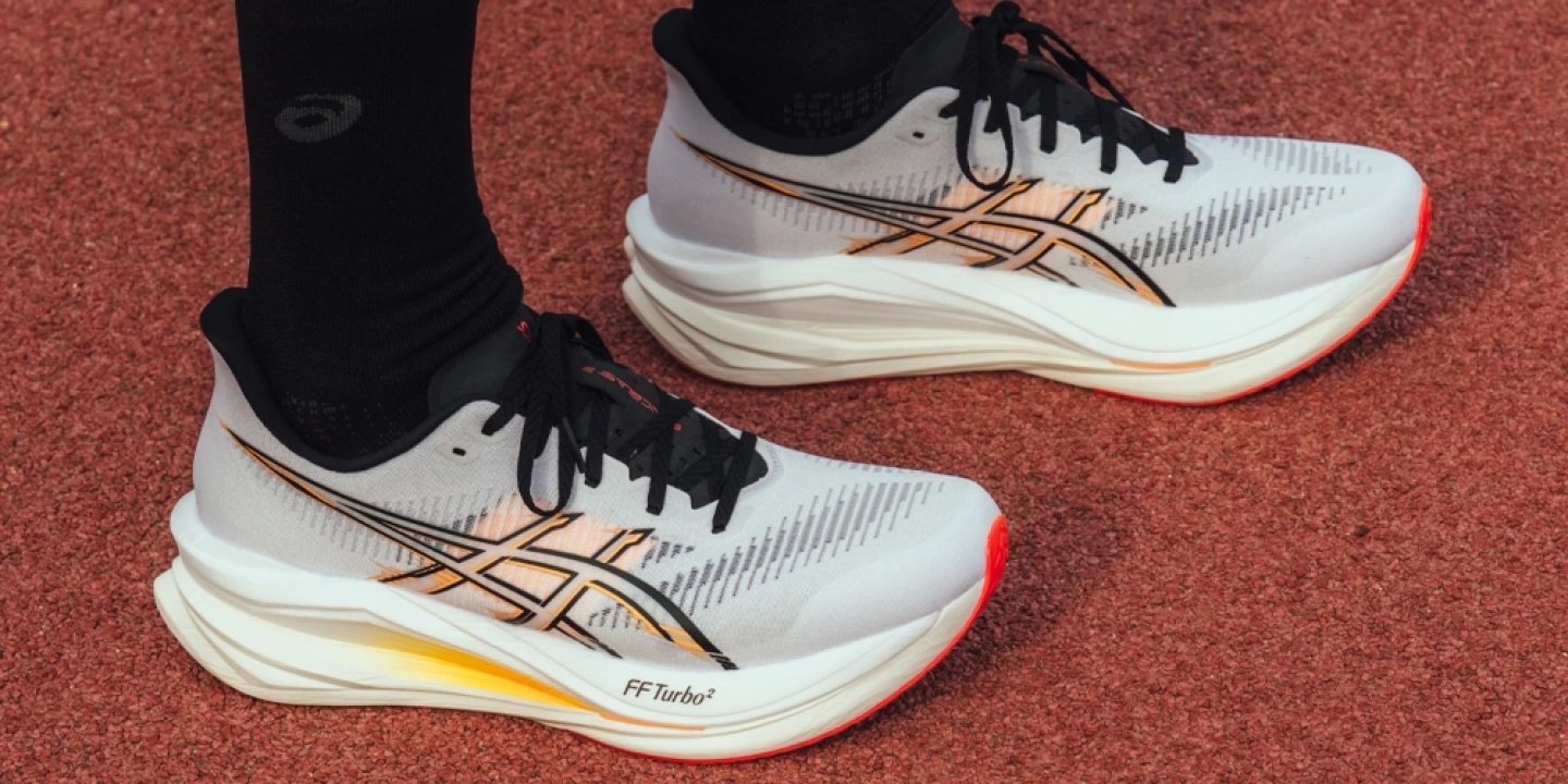 ASICS Sonic Blast 2 Ignite running shoes in white and gold with FF Turbo² midsole on a red athletics track
