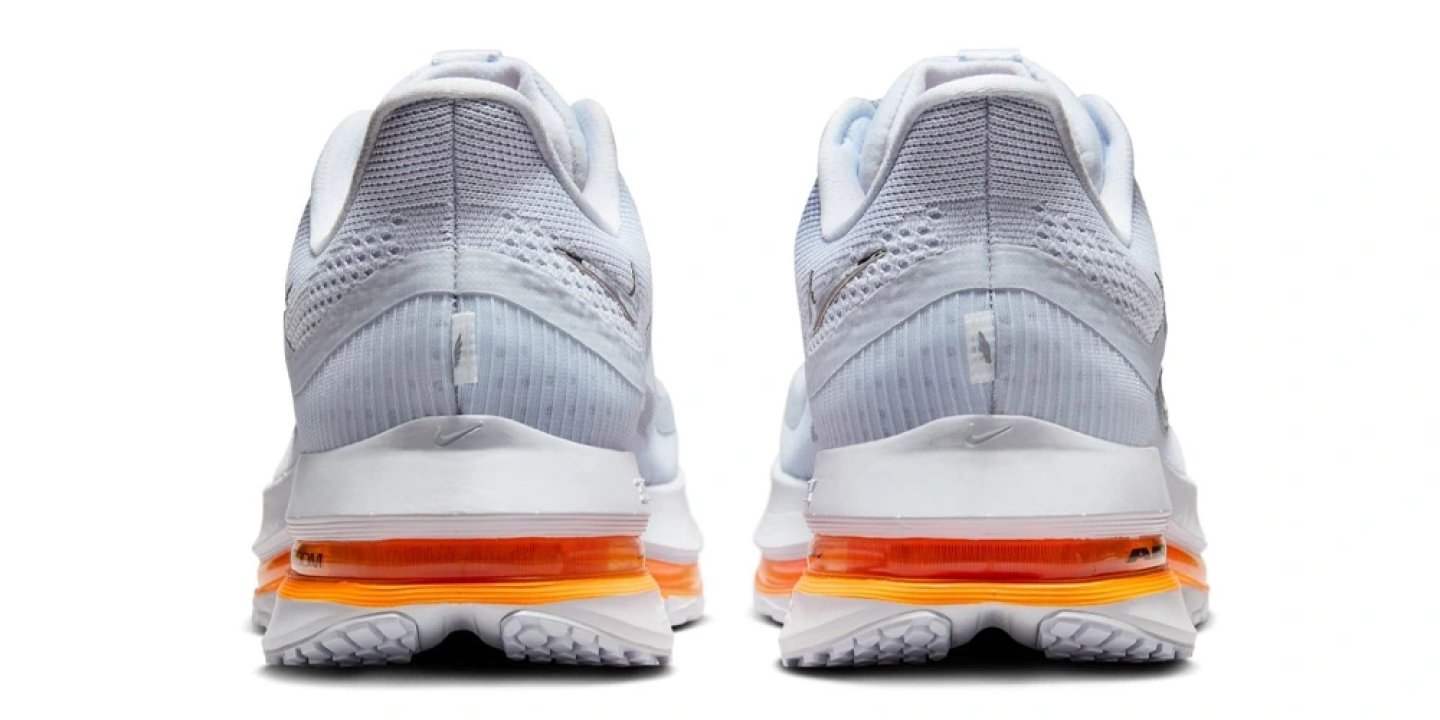 Rear view of Nike Pegasus Premium running shoes in white and grey with a vibrant orange Air cushioning midsole unit