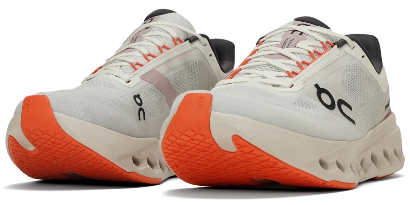 On Cloudsurfer Next Fit running shoes in white with vibrant orange CloudTec sole, rear three-quarter view