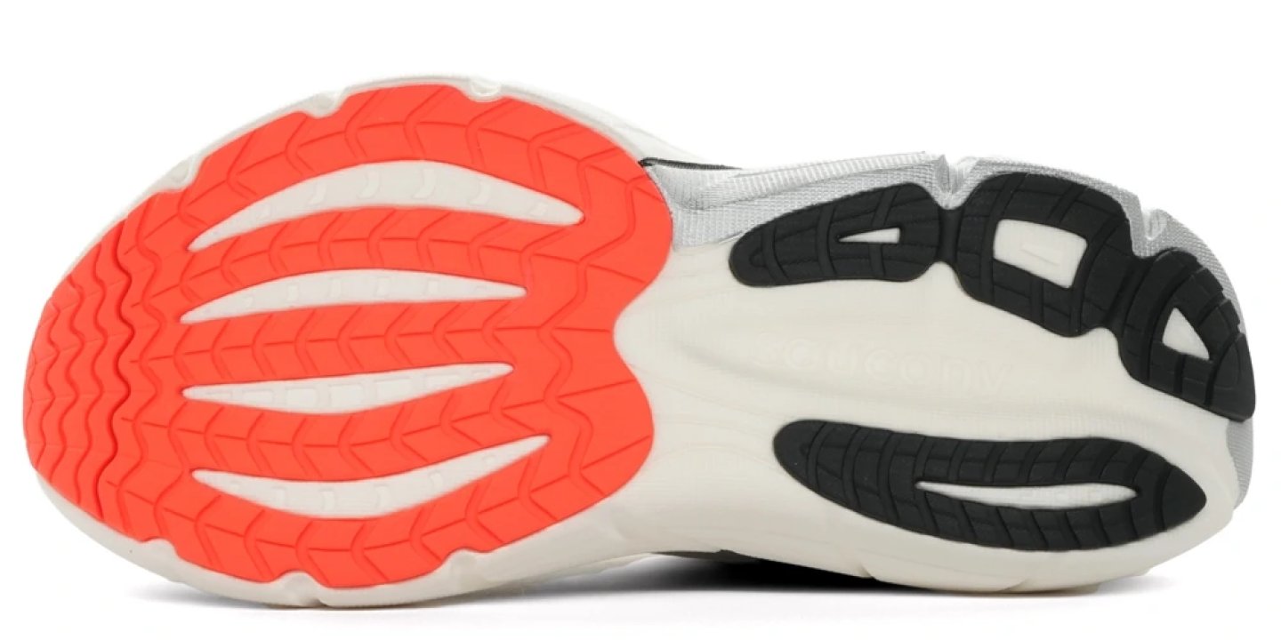 Bottom view of the Saucony Paramount Max running shoe outsole featuring coral forefoot rubber lugs and dark grey heel traction pods