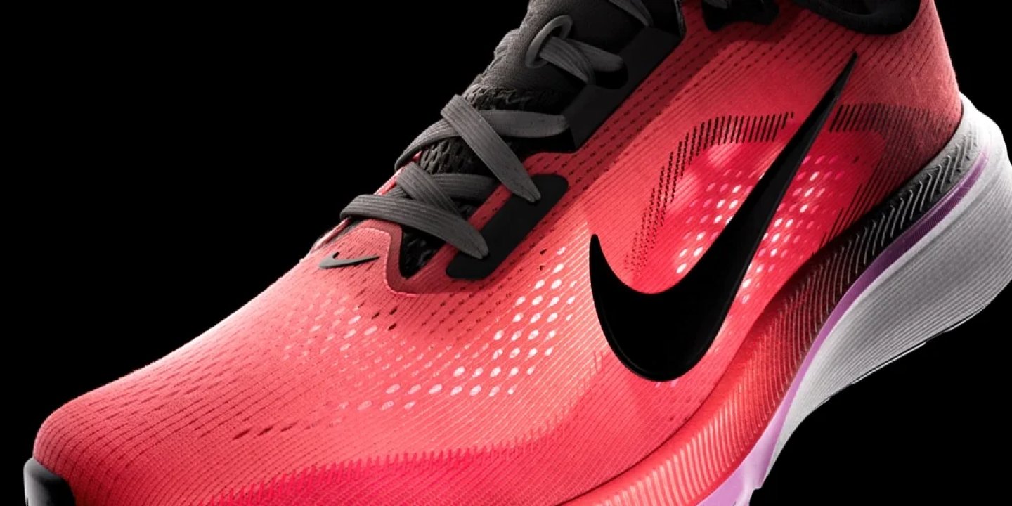Nike performance running shoe in crimson red with black Swoosh, grey laces, and white-purple midsole on black background.