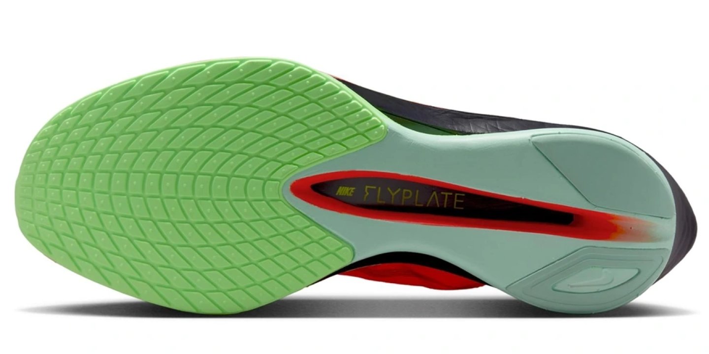 Bottom view of Nike Vaporfly 4 Zool running shoe showing green outsole with FlyPlate carbon plate and red accent detailing