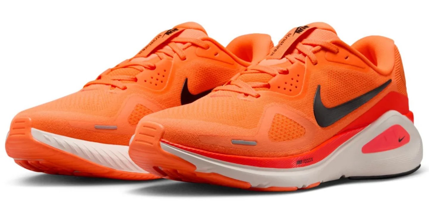 Nike running shoes in orange with black Swoosh, white React midsole, and red heel accent, shown as a pair.