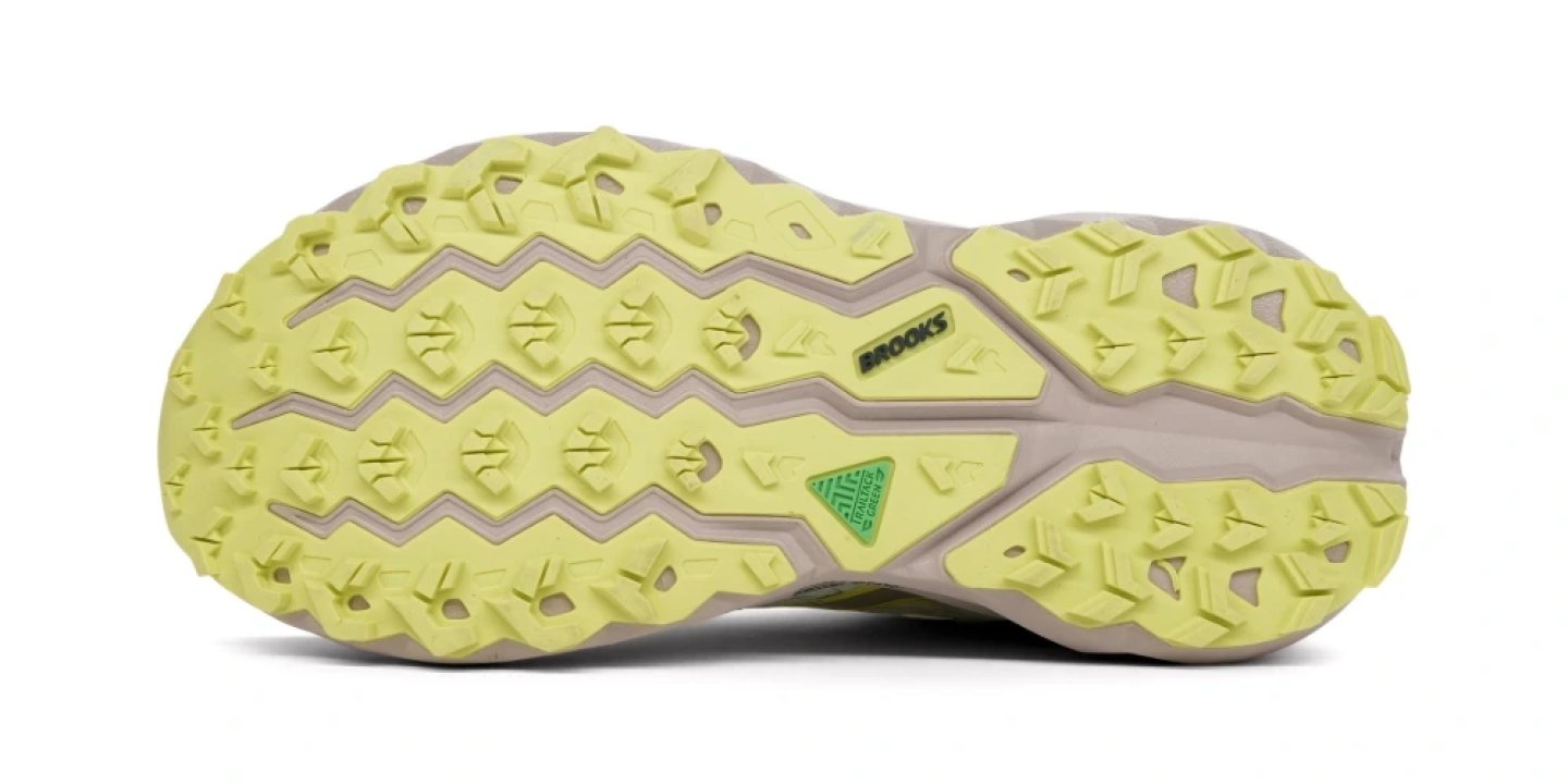 Bottom view of Brooks trail running shoe outsole in lime yellow with aggressive multidirectional lugs.