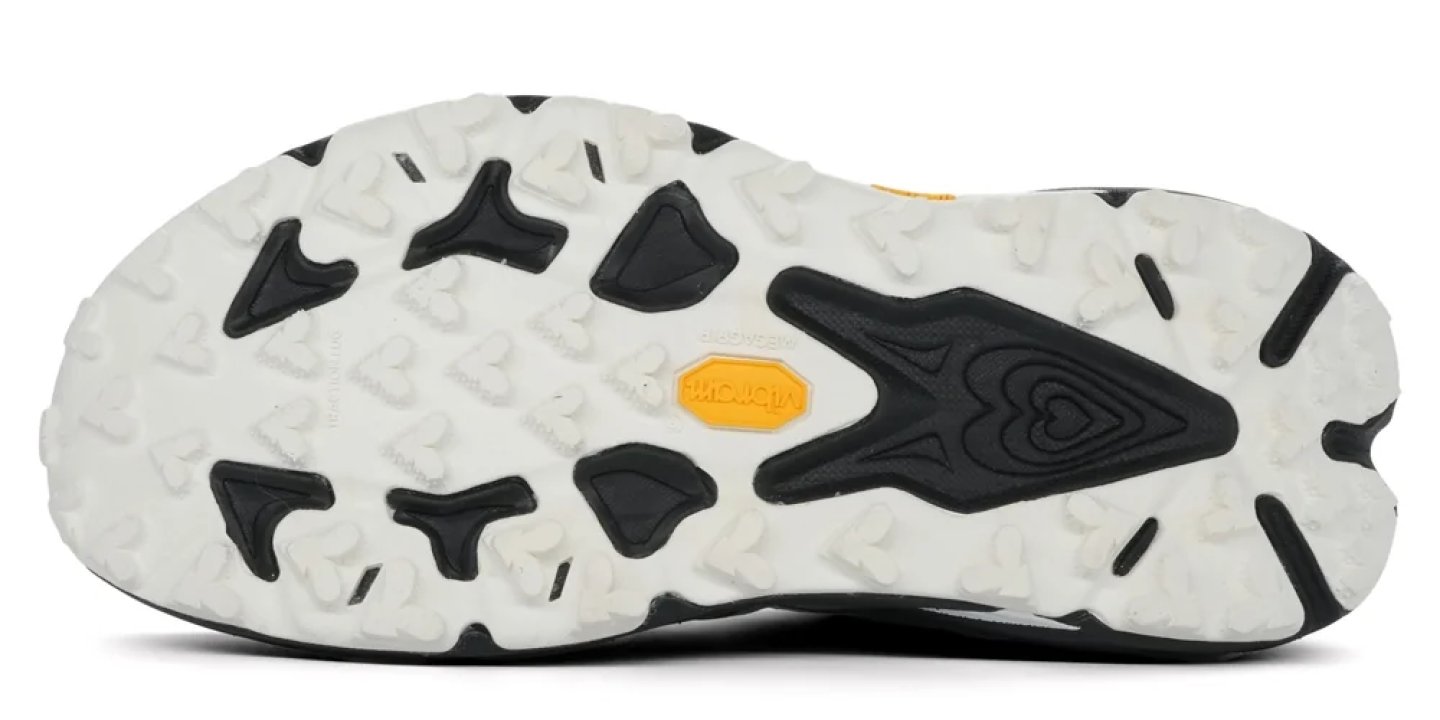 Mammut trail running shoe outsole with white and black aggressive rubber lugs and yellow brand logo badge.