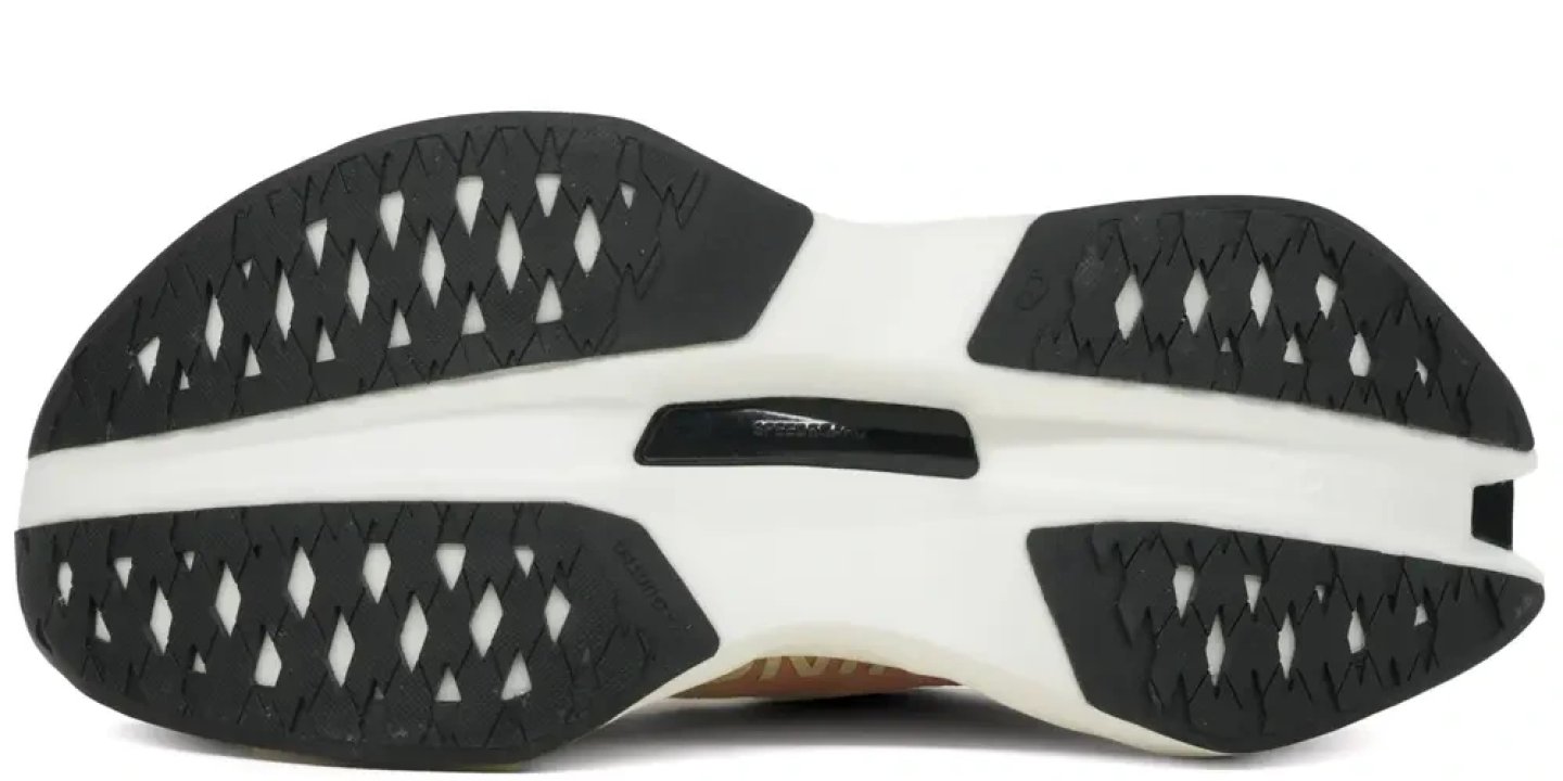 Bottom view of On running shoe showing black geometric rubber outsole lugs on white midsole with zigzag traction pattern