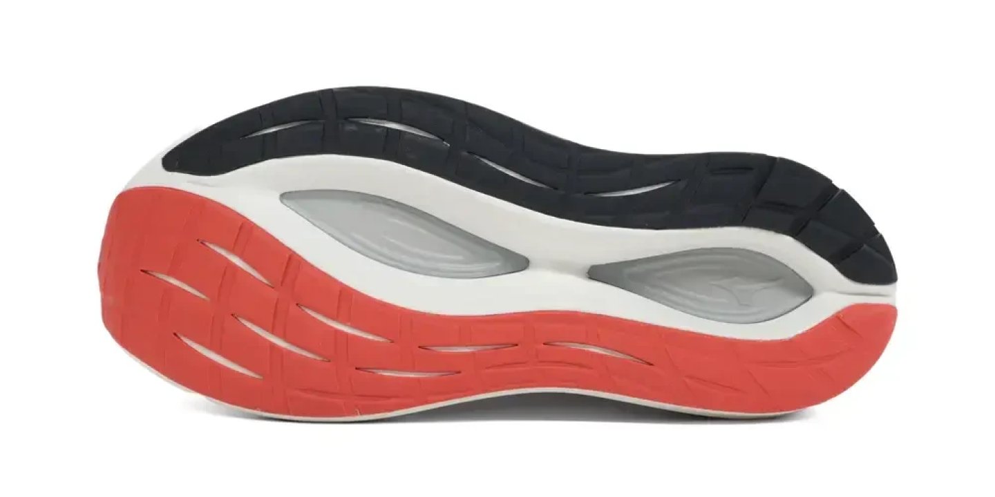 Bottom view of Mizuno running shoe outsole showing black rubber traction zones, red and white midsole foam layers