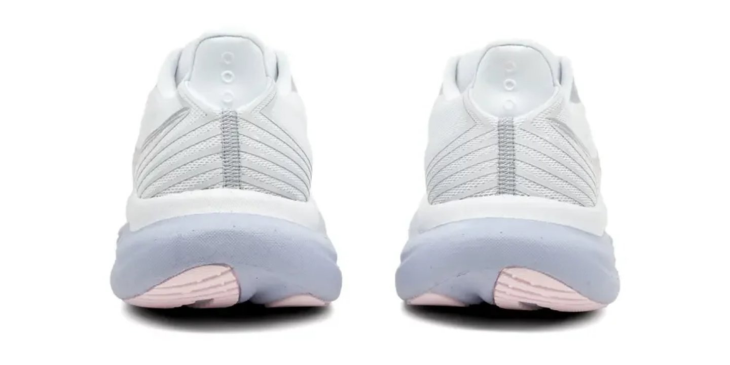 Rear view of a pair of Saucony women's white and grey running shoes with a pink heel outsole accent.